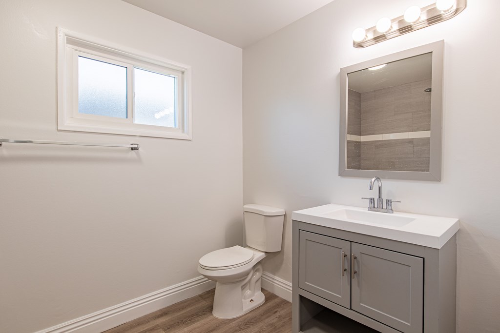 A white toilet sits next to a sink in a small bathroom.