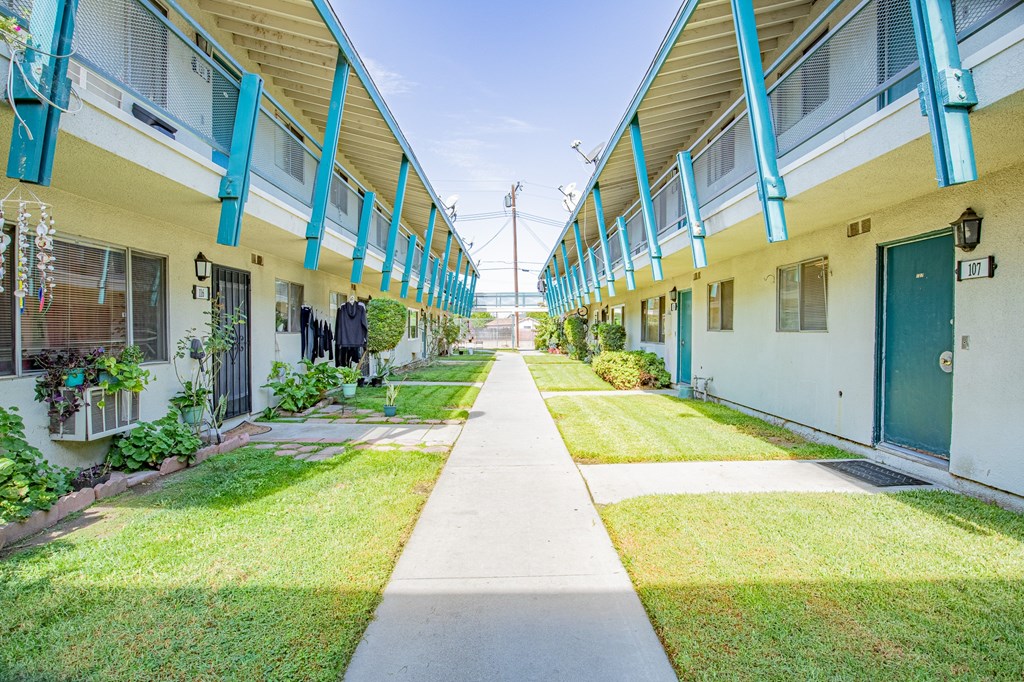 A long white building with blue trim and a green door.