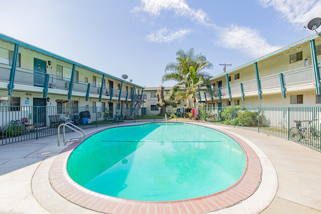 A swimming pool in a courtyard surrounded by apartment buildings.
