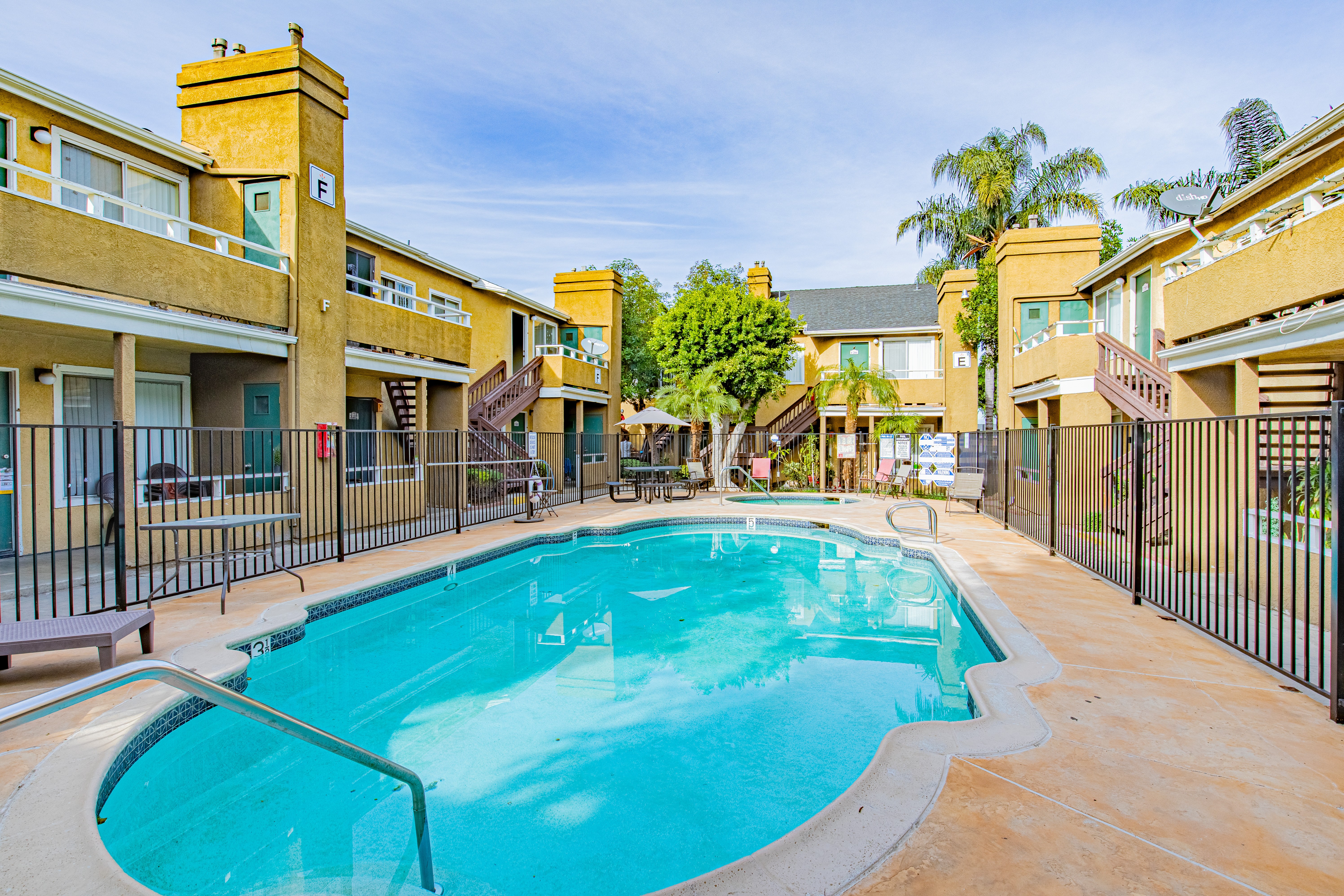 A swimming pool surrounded by a fence and buildings.