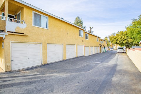A street view of a residential area with apartment buildings and parked cars.