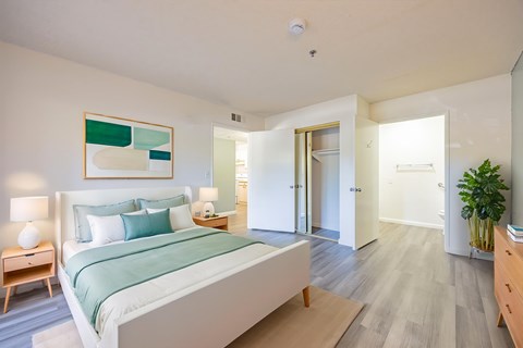 A bedroom with a bed, nightstand, and lamp.