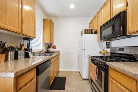 A kitchen with a white refrigerator and black stove.