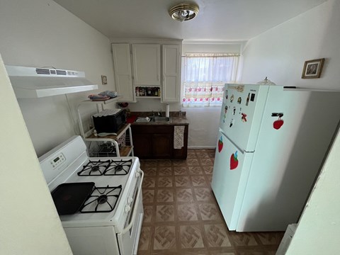A kitchen with a white fridge and a white stove.