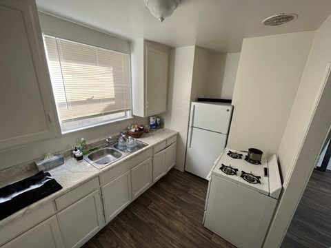 A kitchen with a fridge, a stove, and a sink