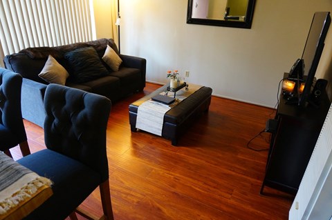 A living room with a black couch, chair, and coffee table.