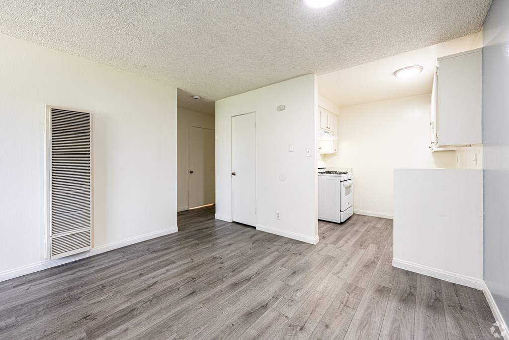 A room with a white fridge and a white cabinet.
