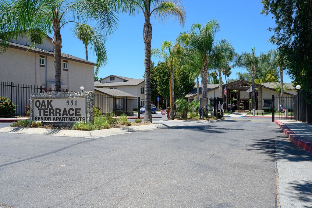 a street with houses on each side and a sign that reads oak 51 terrace at Oak Terrace Senior Apts, Hemet California