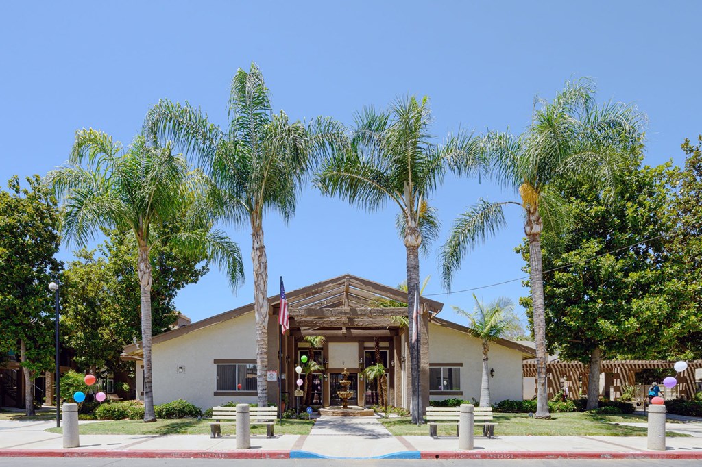 a building with palm trees in front of it at Oak Terrace Senior Apts, Hemet, CA 92543   