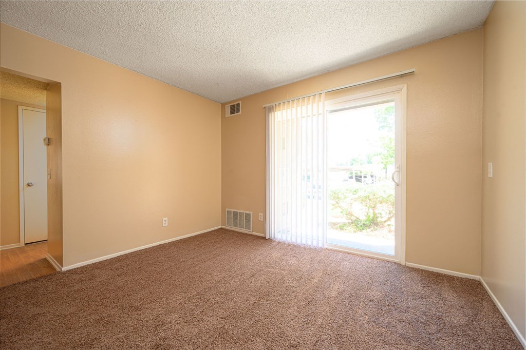 a bedroom with a sliding glass door and a carpeted floor at Oak Terrace Senior Apts, California, 92543