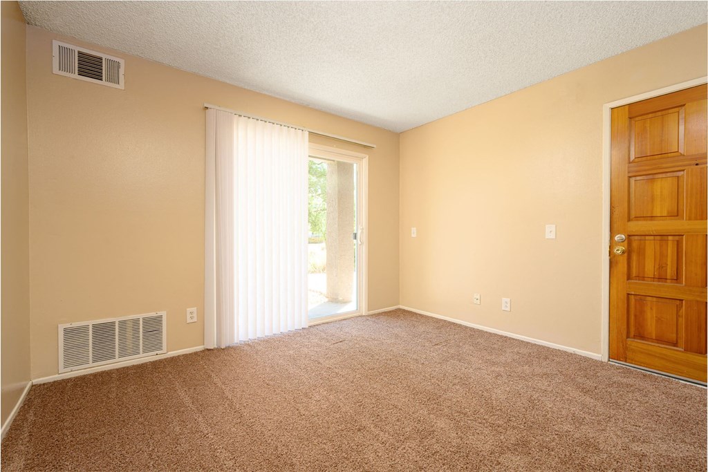 a bedroom with a door leading to a patio at Oak Terrace Senior Apts, Hemet, CA