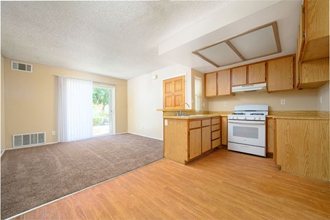 a kitchen and living room with a sliding glass door leading to a patio at Oak Terrace Senior Apts, Hemet California