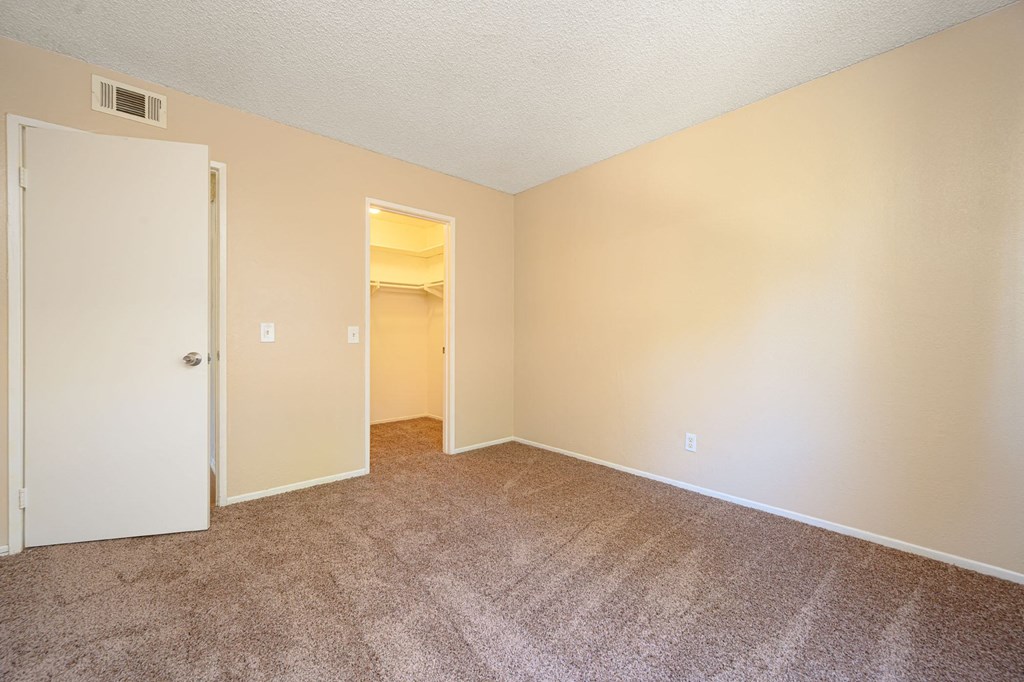 a bedroom with a carpeted floor and an open door at Oak Terrace Senior Apts, Hemet California