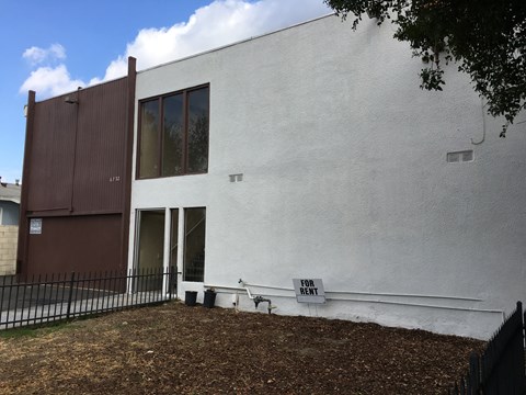 A white building with a brown door and windows.