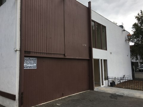 A white building with a brown garage door.