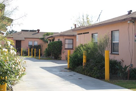 A row of houses with a sidewalk in front.