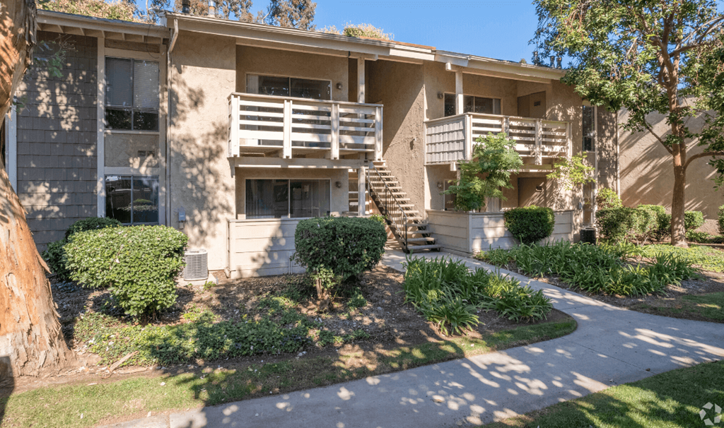 an apartment building with a sidewalk in front of it  at Alosta Place, Azusa, CA