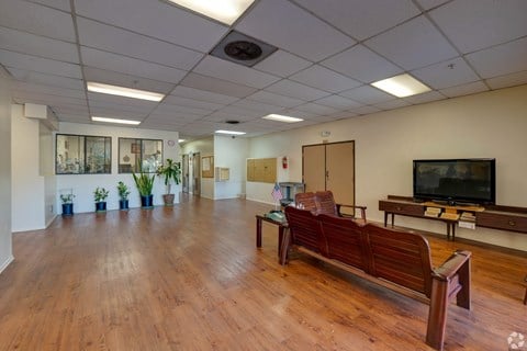a large room with wooden floors and a television in the corner at Flamingo Garden Senior Apts, El Monte, 91732
