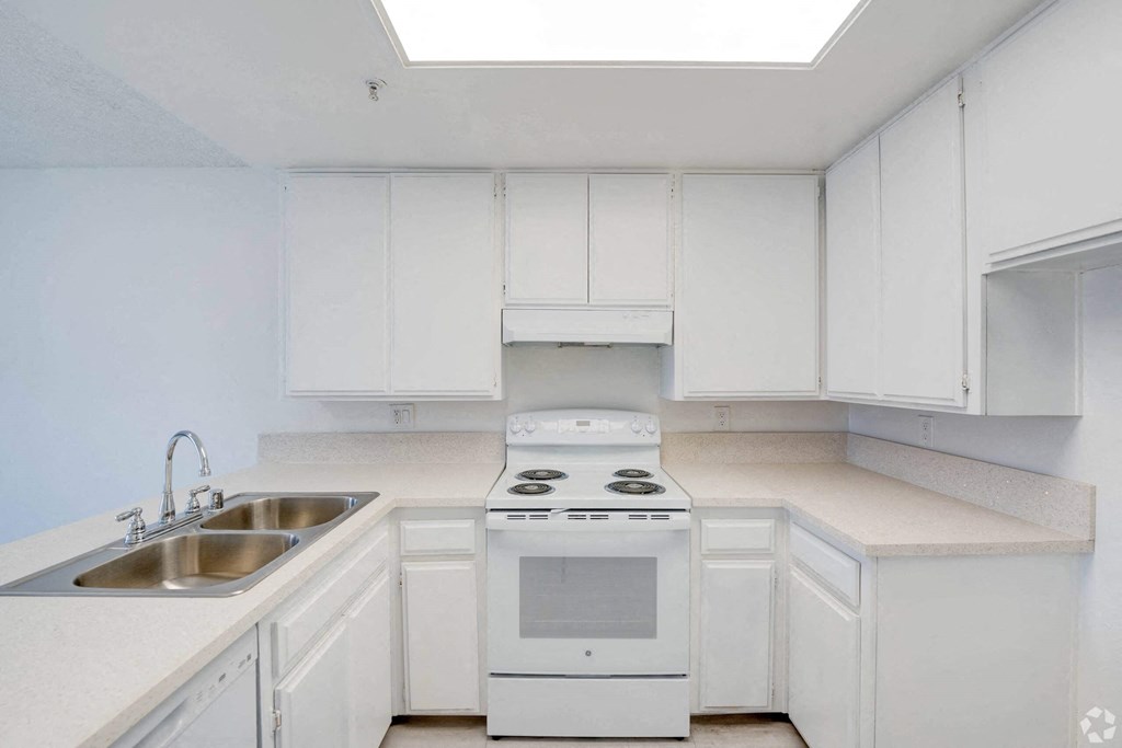 a kitchen with white cabinets and white appliances and a sink a kitchen with white cabinets and white appliances and a sink at Flamingo Garden Senior Apts, El Monte, CA 91732