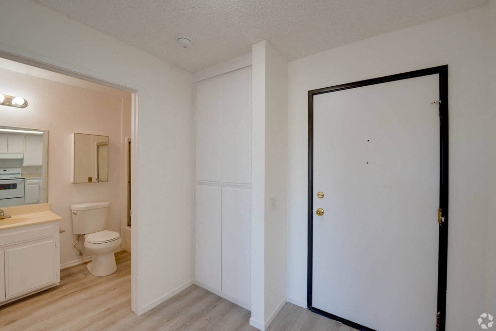 a bedroom with a door leading into a bathroom with a toilet and sink a bedroom with a door leading into a bathroom with a toilet and sink at Flamingo Garden Senior Apts, El Monte California