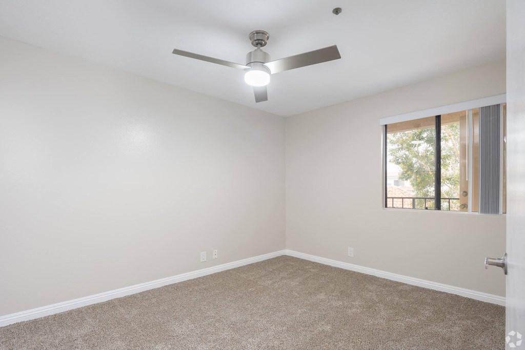 an empty room with a ceiling fan and a window at Huntington Terrace North Senior, Huntington Beach, CA 92648
