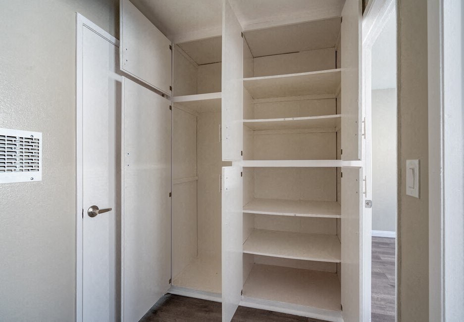 a closet with empty shelves and a door at North View Terrace, Montebello California