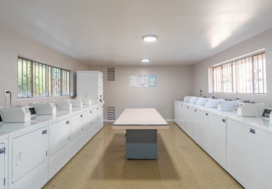 an empty kitchen with white cabinets and a table at North View Terrace, Montebello, CA