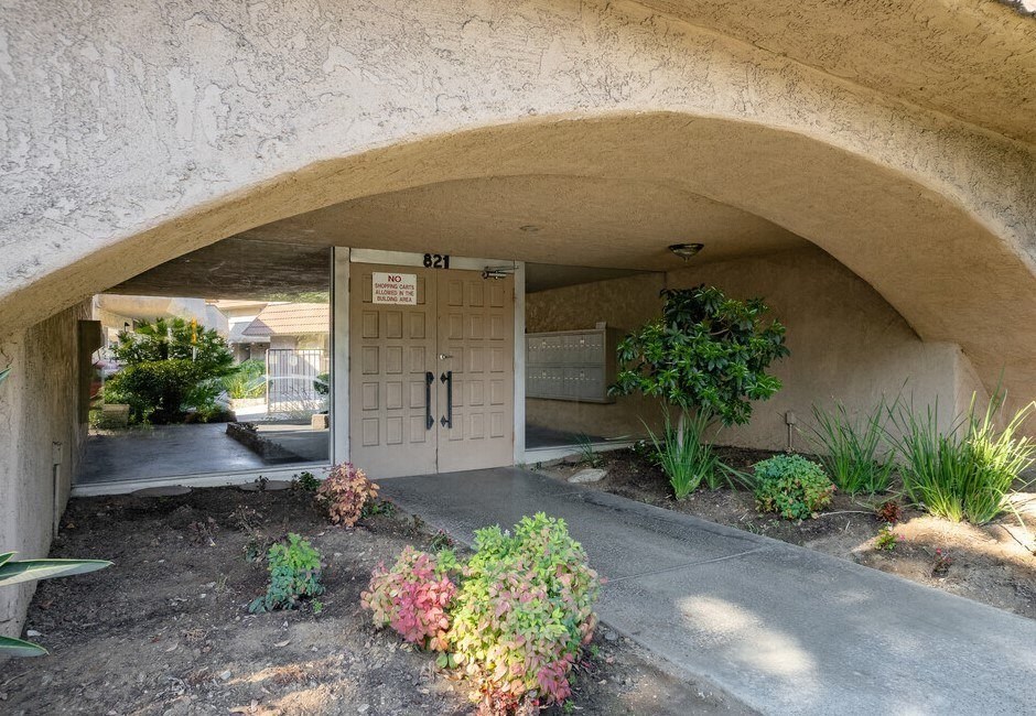 the front door of a building with a flower garden in front of it at North View Terrace, Montebello, CA 90640