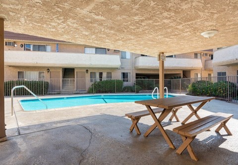 a pool with a picnic table in front of an apartment building at North View Terrace, California 
