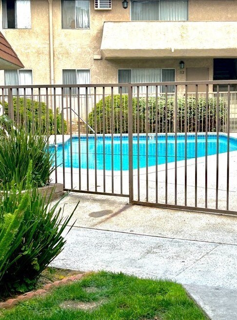 a swimming pool is behind a wrought iron fence at North View Terrace, Montebello, CA 90640