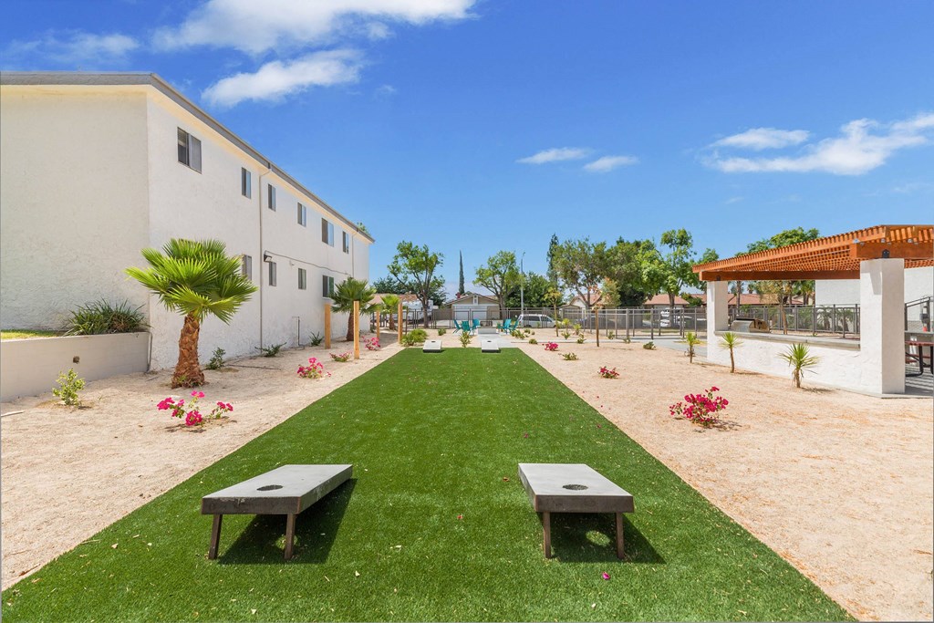 a garden outside a building with grass and benches at Sunnymead Apts Apartments, Moreno Valley, CA