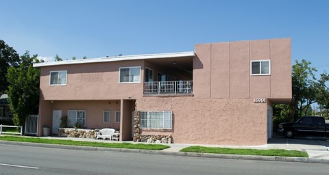 A pink house with a black car parked in front.