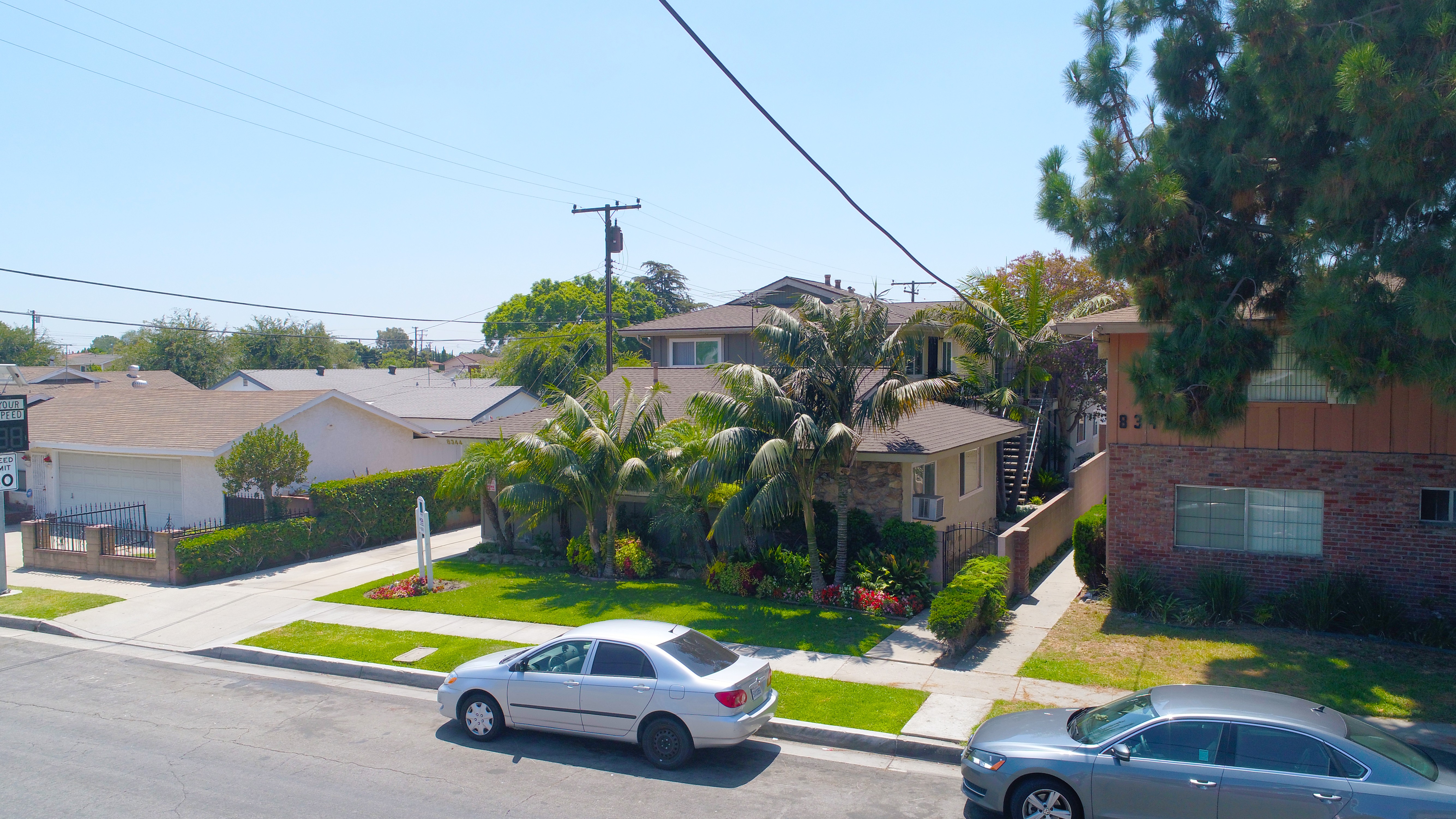A residential street with cars parked on the side.