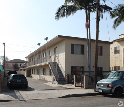 A street view of a residential area with a building numbered 132.