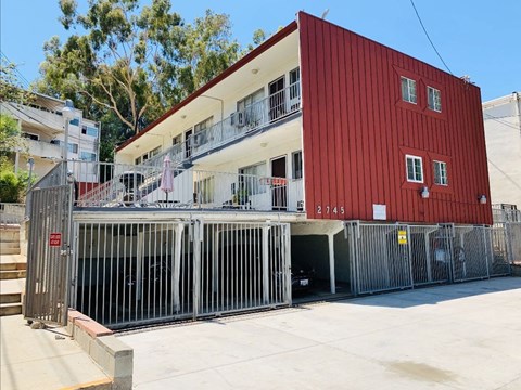 A red building with a white balcony and a sign that reads 2745.