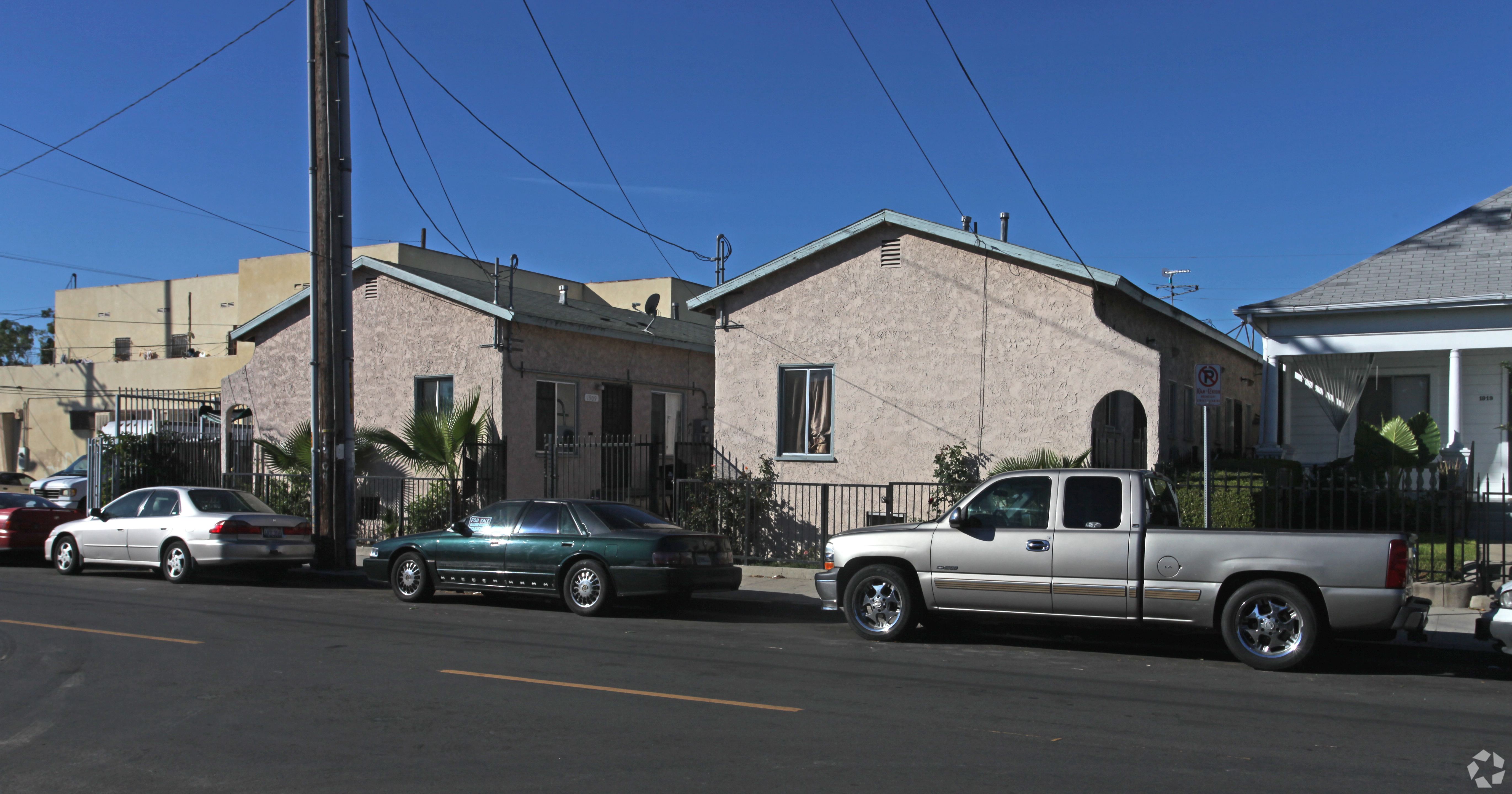 A silver truck is parked in front of a house.
