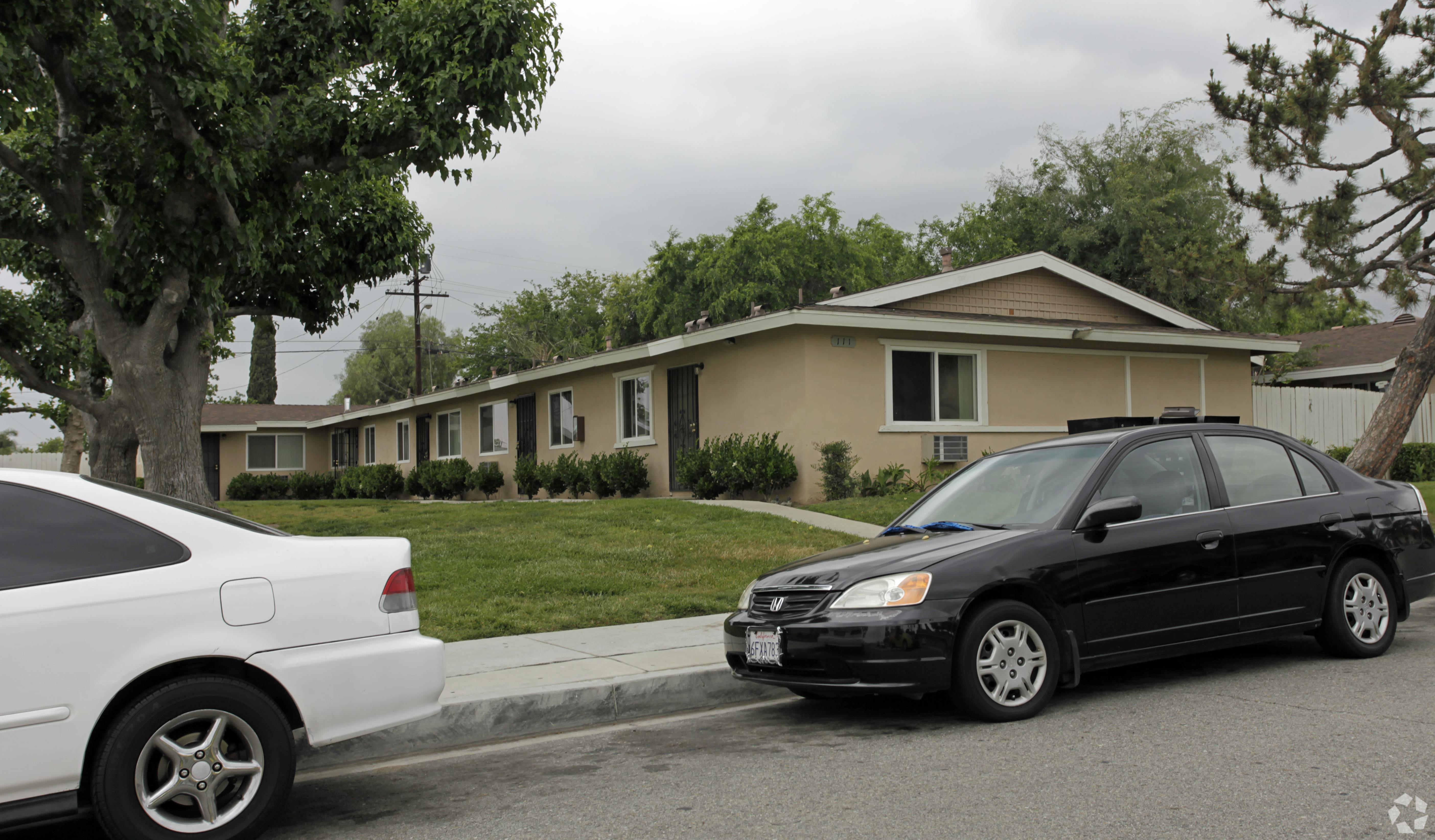 Two cars parked in front of a house.