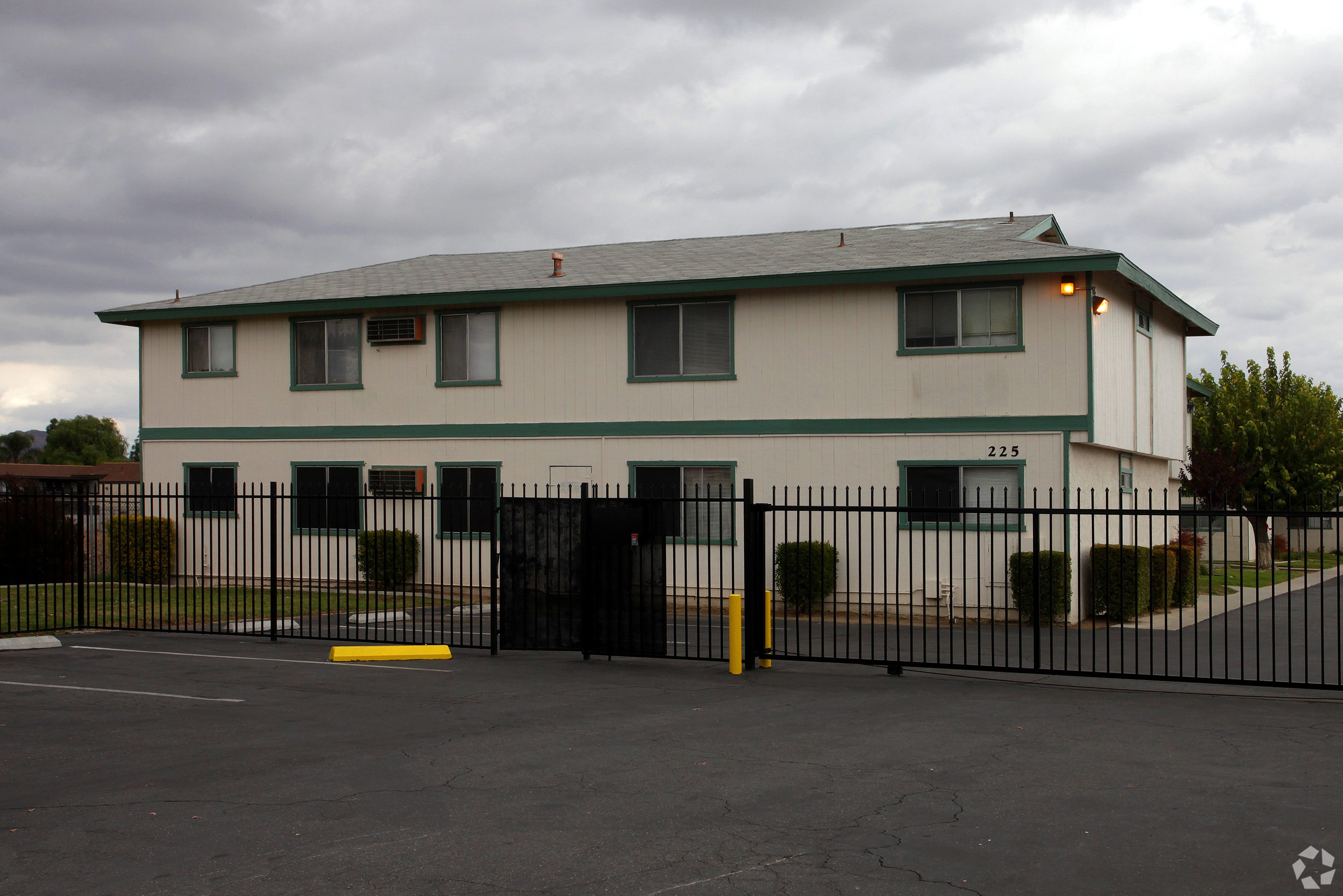 A white building with a black fence in front.