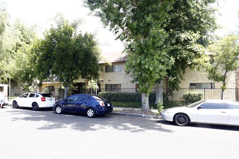 Three cars parked in front of a building.