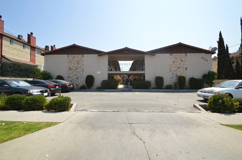 A large white building with a stone facade and a brown roof.