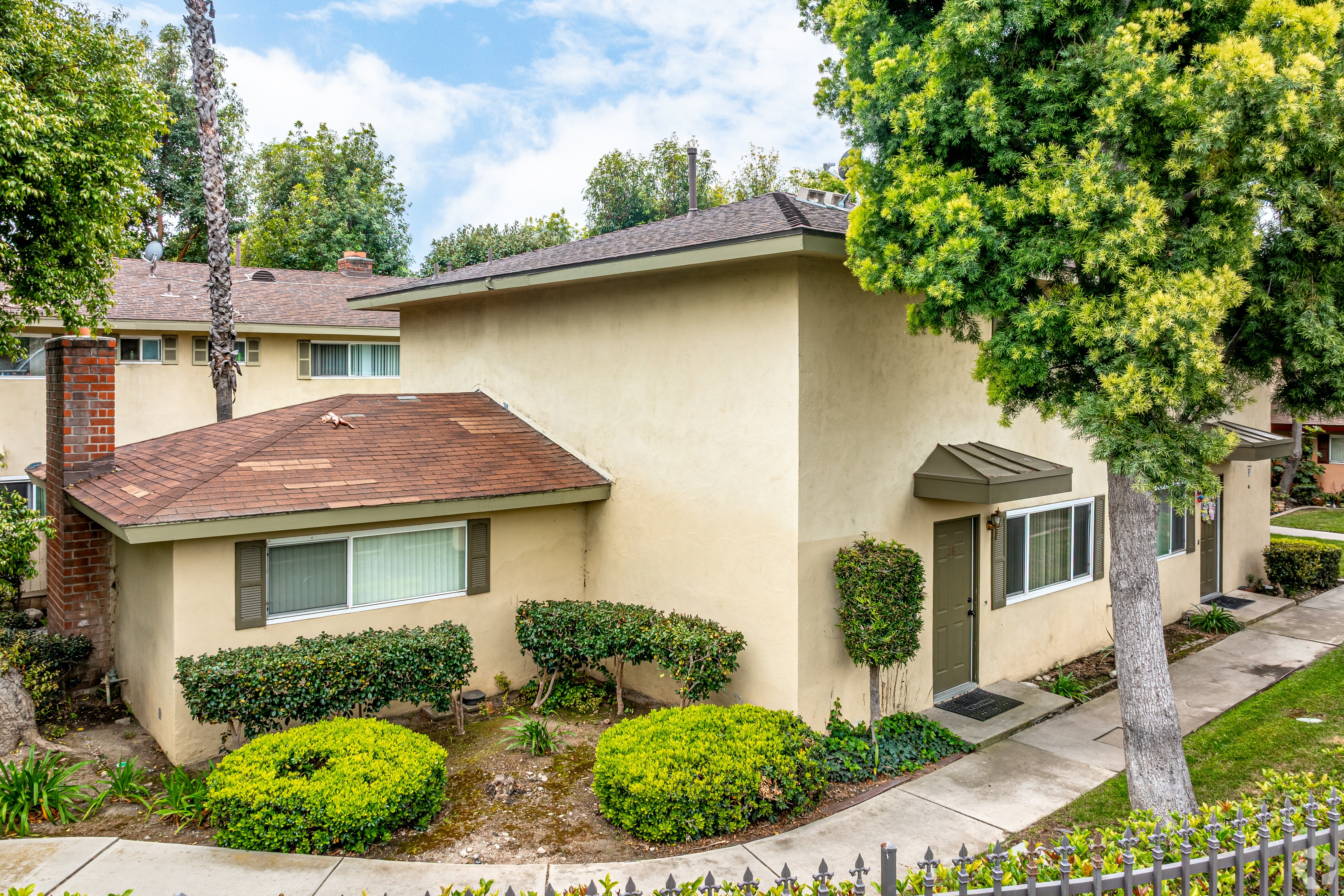 A house with a brown roof and a white fence.