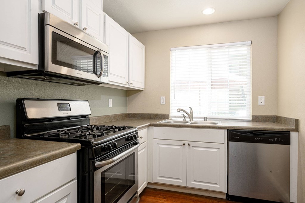 a kitchen with white cabinets and stainless steel appliances at Sagewood Gardens Senior Apartments, Hacienda Heights, CA 91745