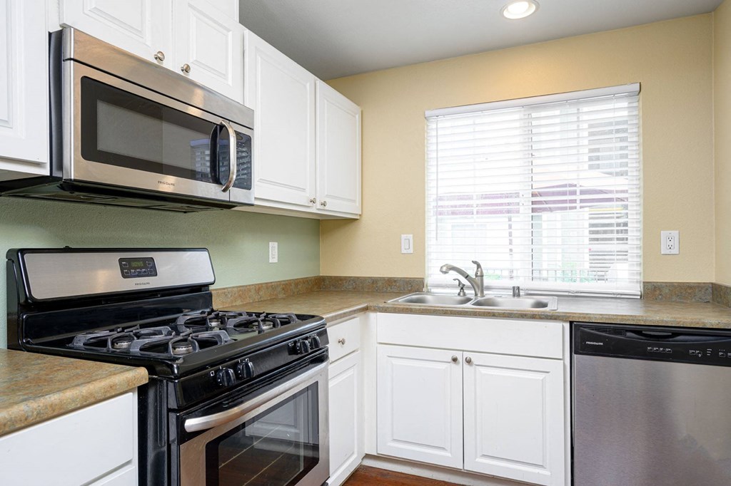 a kitchen with white cabinets and black appliances at Sagewood Gardens Senior Apartments, Hacienda Heights, CA 91745