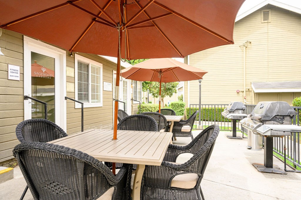 a patio with a table and chairs and an umbrella at Sagewood Gardens Senior Apartments, Hacienda Heights, CA 91745