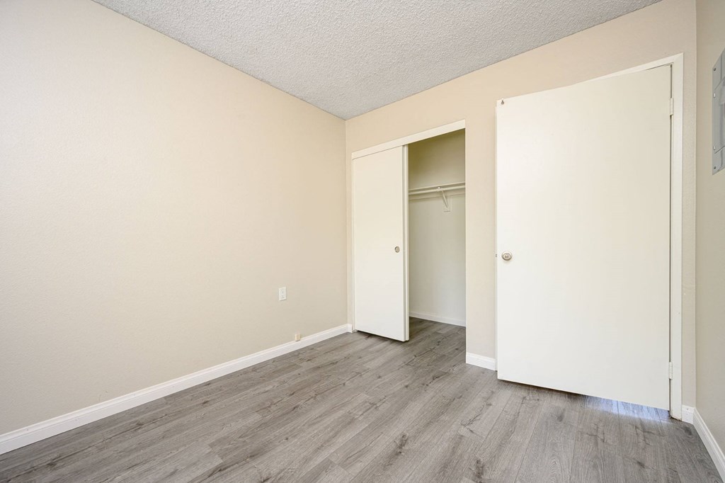 a bedroom with hardwood floors and beige walls at Sagewood Gardens Senior Apartments, Hacienda Heights, 91745