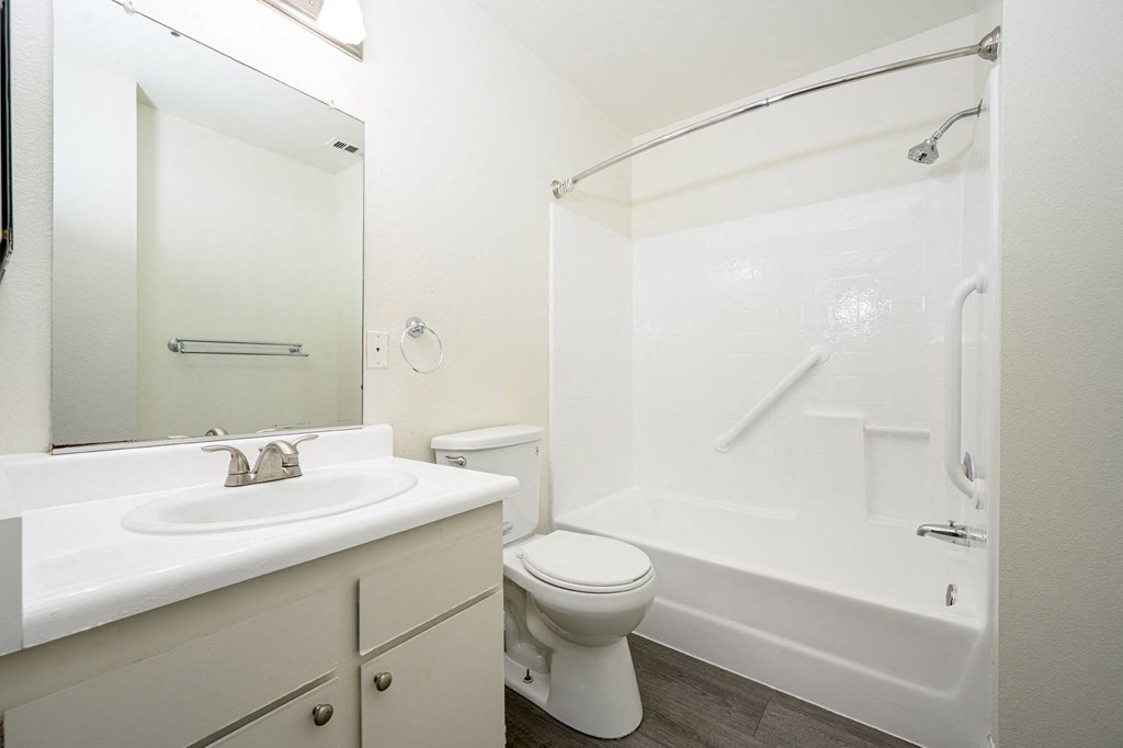 a bathroom with a bathtub toilet sink and mirror at Sagewood Gardens Senior Apartments, Hacienda Heights, CA