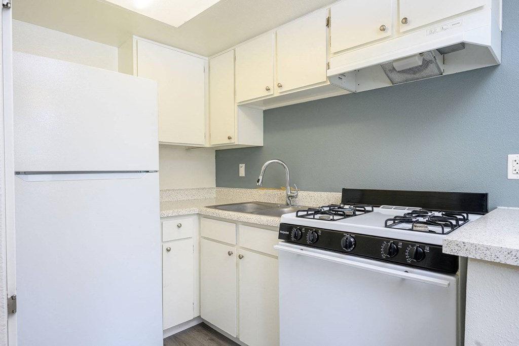 a kitchen with white cabinets and a white stove top oven a kitchen with white cabinets and a white stove top oven at Sagewood Gardens Senior Apartments, Hacienda Heights