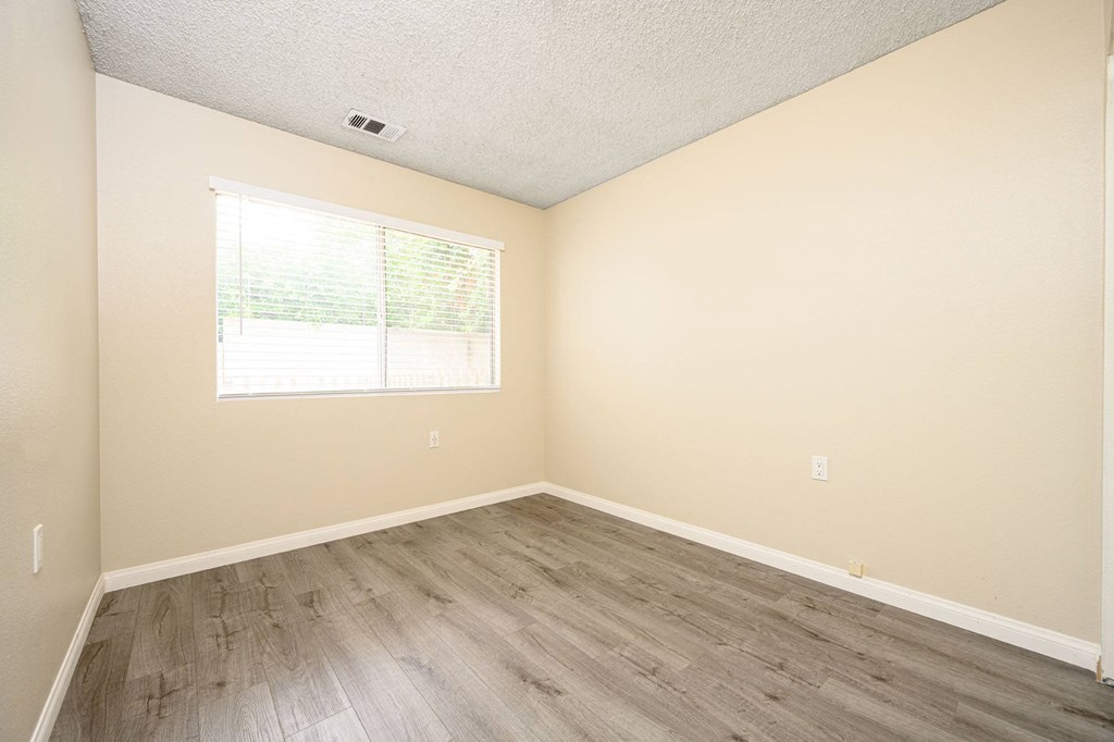 a bedroom with hardwood floors and beige walls at Sagewood Gardens Senior Apartments, Hacienda Heights, 91745