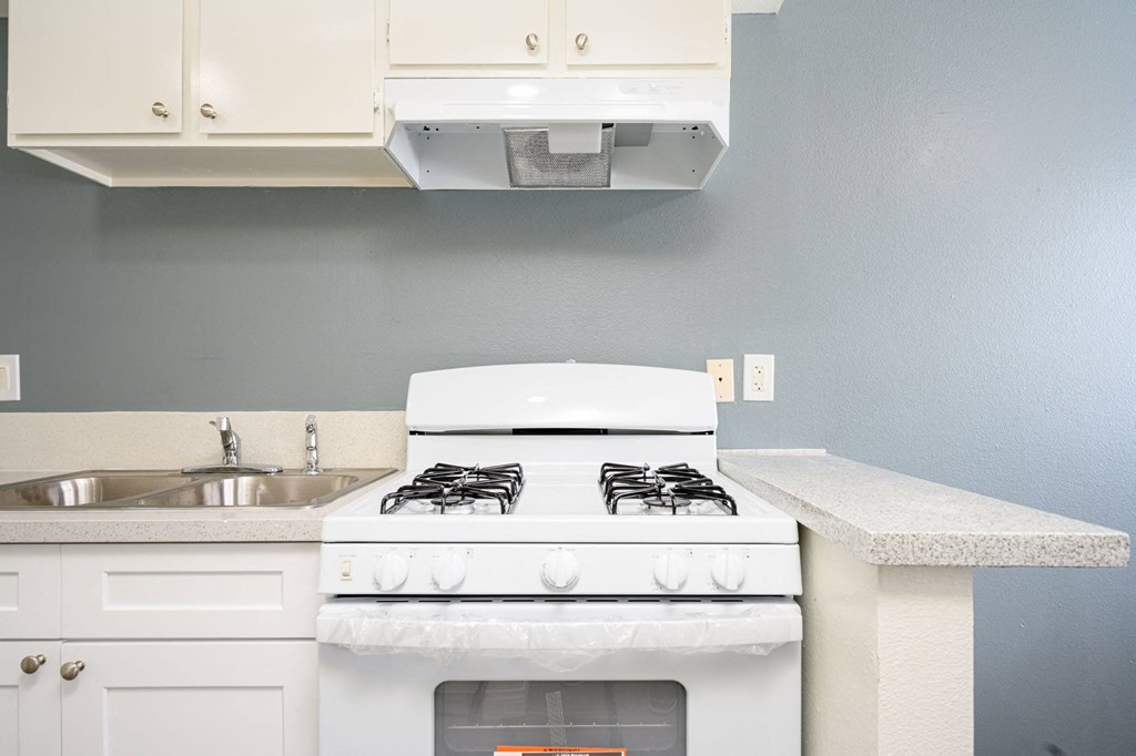 a kitchen with a stove top oven next to a sink