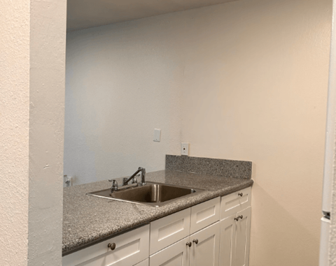A kitchen with a granite countertop and white cabinets.